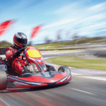 Go kart driver trail braking into a corner on a race track, showing braking while turning technique