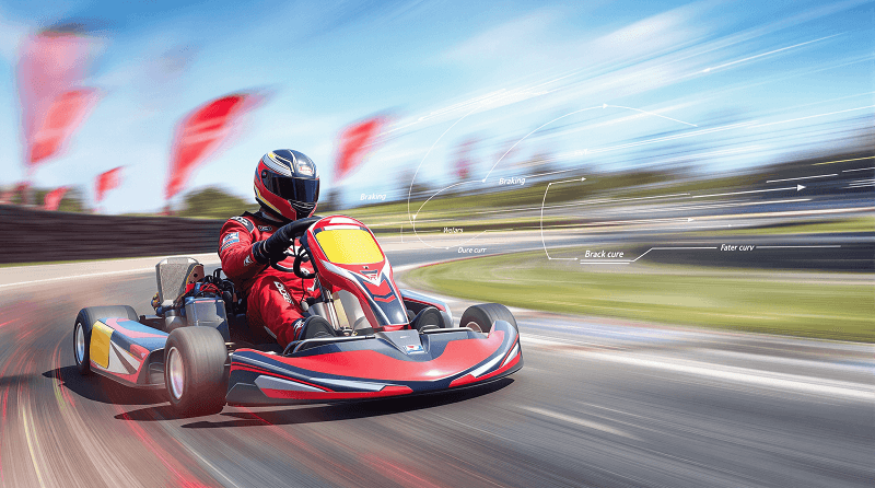 Go kart driver trail braking into a corner on a race track, showing braking while turning technique